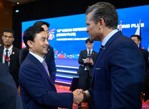 Defense Minister Ahn Gyu-back (L) and US Defense Secretary Pete Hegseth shake hands during the ASEAN Defense Ministers