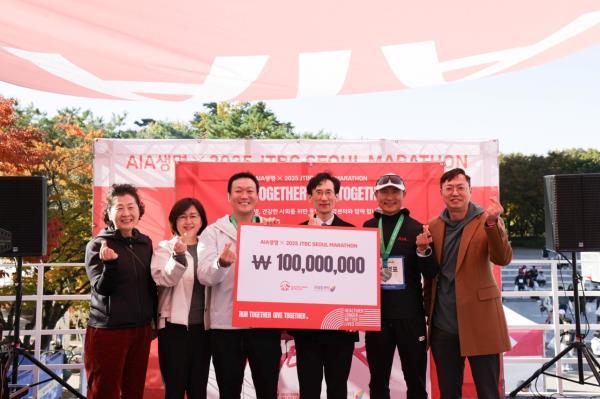 AIA Korea CEO Nathan Chuang (third from left) poses for a picture with officials from the local cancer community after delivering a donation to the National Cancer Center at the 2025 JTBC Seoul Marathon in Seoul on Sunday.  (AIA Korea)